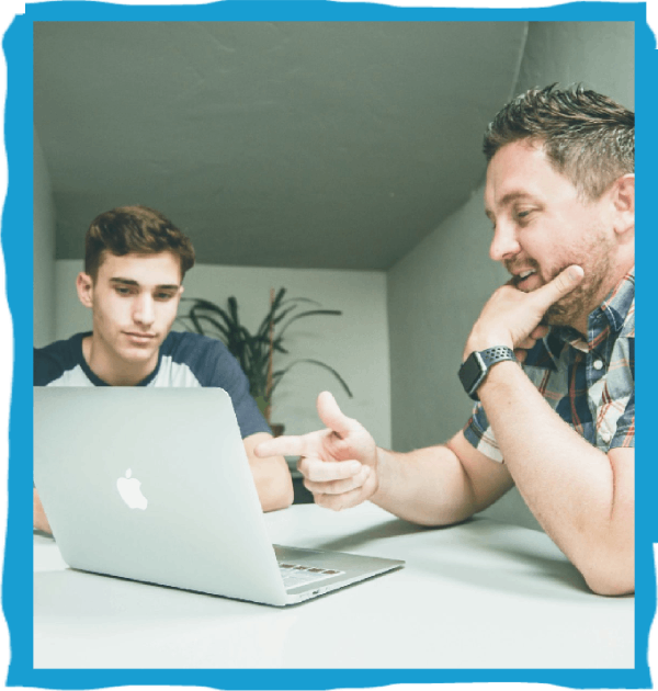 Two people discussing laptop screen