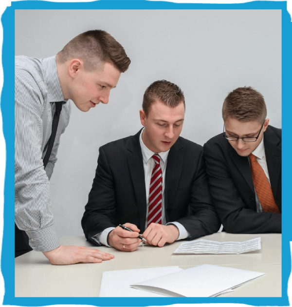 Three men discussing paperwork